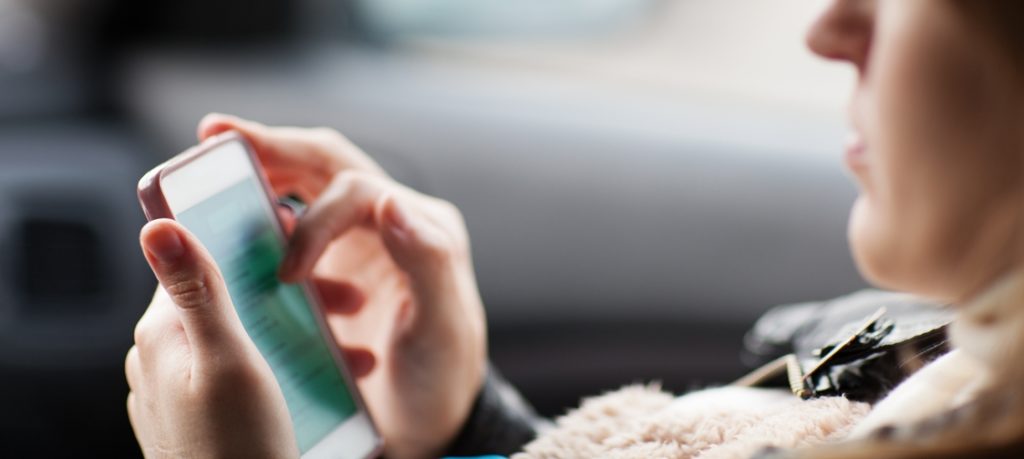 pregnant woman using phone in car